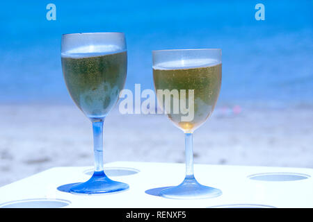 Deux verres de bière par la mer. Des bières fraîches dans des verres sur la table de resort sur la côte de l'océan. Bénéficiant d'autres tropicales. Deux verres de bière sur la plage. Un froid Banque D'Images