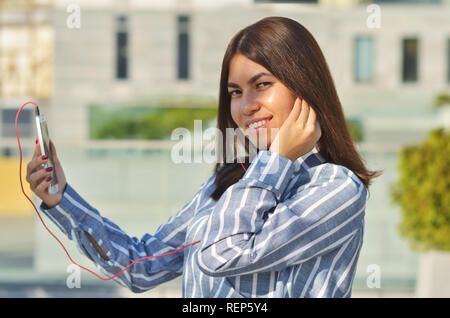 Une jeune étudiante d'apparence asiatique vêtue d'une chemise rayée Banque D'Images