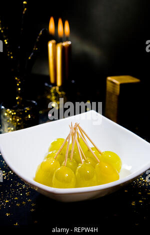 12 grains de raisins dans un bol blanc avec des bougies et fond de Noël Banque D'Images