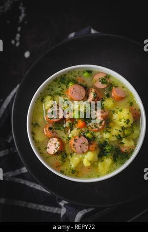 Ragoût avec des légumes frais et des saucisses sur un arrière-plan foncé moody Banque D'Images