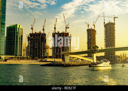 Dubaï, Émirats arabes unis 11. 10. 2018 : les contractions de Dubaï sur la côte avec des grues en ligne everywere coucher du soleil et d'un bateau de touristes Banque D'Images