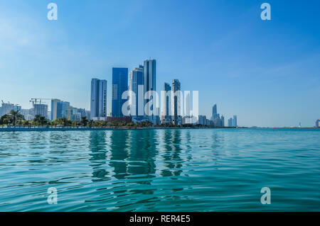 La ville d'Abu Dhabi Corniche le long beach prises à partir d'un bateau en eau Banque D'Images