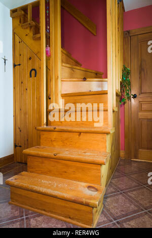 Escalier en bois de pin menant à l'étage supérieur à l'intérieur d'une ancienne maison de style cottage de 1927. Banque D'Images