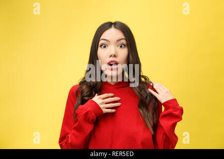 Choqué peur belle jeune femme avec la bouche largement ouverte, la caméra regarde se rend compte qu'elle a déçu avec quelque chose, isolé sur fond jaune studio. Banque D'Images