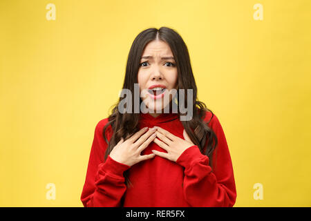 Choqué peur belle jeune femme avec la bouche largement ouverte, la caméra regarde se rend compte qu'elle a déçu avec quelque chose, isolé sur fond jaune studio. Banque D'Images