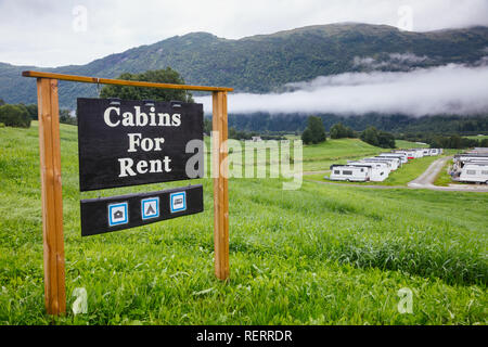 Chalets à louer au camping en Norvège Scandinavie avec vue sur les montagnes pittoresques. Camping-remorques et cabines vu en arrière-plan Banque D'Images