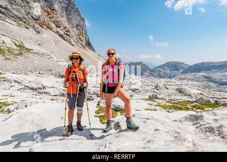 Deux randonneurs se pencher sur l'appareil photo, paysage de montagne, Stuhlgraben Hinterten Grießkogel,, Steinernes Meer, Funtenseetauern Banque D'Images