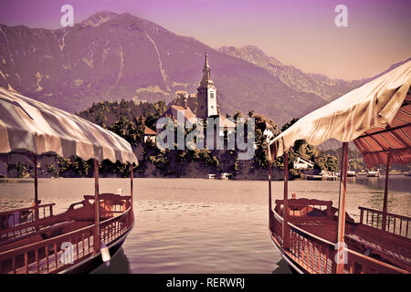 Bateaux en bois typiques, en slovène appelé 'Pletna Les', dans le lac de Bled, le lac le plus célèbre en Slovénie avec l'île de l'église (Europe - Slovénie) - Banque D'Images