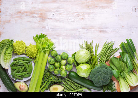 La saine alimentation vegan concept. Les légumes verts sur le tableau blanc les pousses de pois Haricots courgettes avocat céleri bok choy, vue du dessus, copy space Banque D'Images