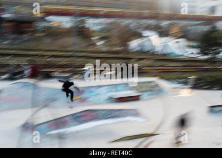 Un patineur à Berlin avec un train dans l'arrière-plan Banque D'Images