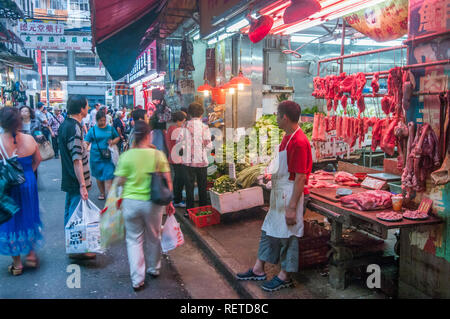 Les gens magasinent pour une variété de biens et services dans des marchés en plein air avec des couleurs vibrantes à Hong Kong, Chine Banque D'Images