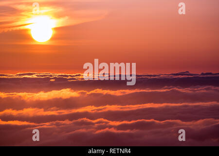 La lumière du soleil reflétée sur une mer de nuages avant le coucher du soleil Banque D'Images