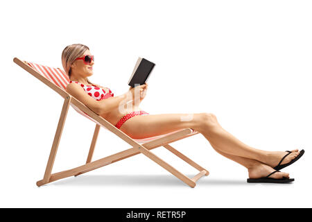 Jeune femme dans une chaise de terrasse en lisant un livre isolé sur fond blanc Banque D'Images