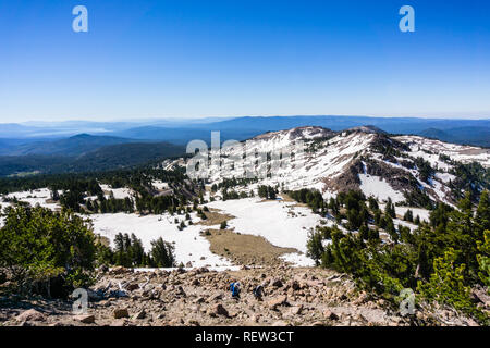 Randonnées vues depuis le sentier à pic Lassen avec des crêtes et des vallées encore couverte de neige et de Lake Almanor visible à l'arrière-plan ; Lassen Volcanic N Banque D'Images