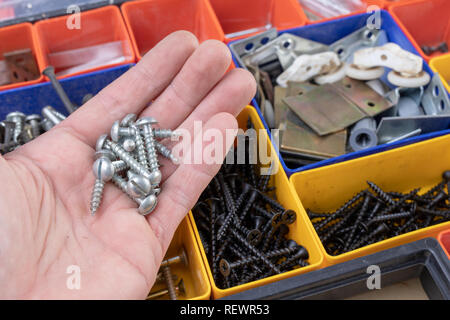 Vis et chevilles pour accueil réparation. Accessoires pour atelier mécanique sur une table. Fond clair. Banque D'Images