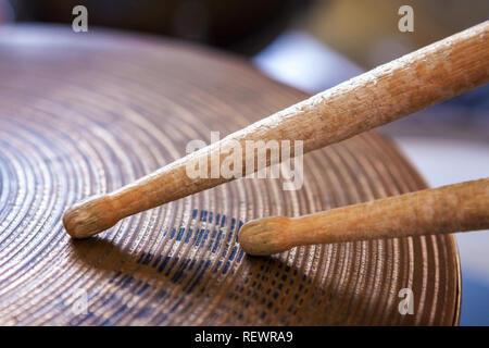 Gros plan d'une paire de baguettes gisant sur la cymbale ride. Banque D'Images