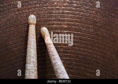 Gros plan d'une paire de baguettes gisant sur la cymbale ride. Banque D'Images