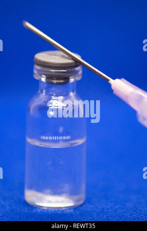 Concept de médicament et de la médecine. Ampoules médicales, la seringue et injecter sur le fond bleu. Banque D'Images