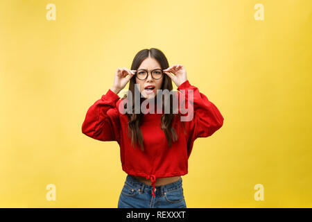 Choqué peur belle jeune femme avec la bouche largement ouverte, la caméra regarde se rend compte qu'elle a déçu avec quelque chose, isolé sur fond jaune studio. Banque D'Images