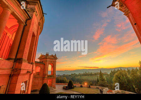 Paysage de collines au-dessus de Bologna à partir d'une fenêtre sur le portique de San Luca Sanctuaire avec un superbe coucher du soleil la lumière. Vue latérale d'arcades du portique. Vue aérienne sur l'église de la cour. Banque D'Images