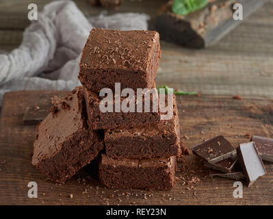 Pile de morceaux carrés de tarte brownie brown cuit sur une planche en bois Banque D'Images
