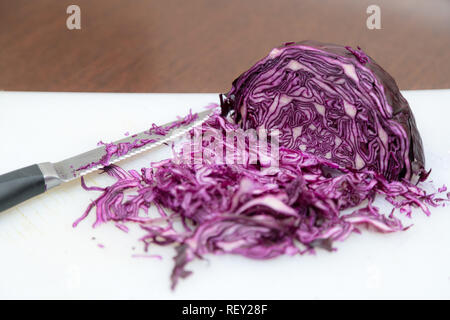 Chou rouge et blanc haché sur fond en bois avec couteau de cuisine sur le côté. Vue de dessus culinaire Banque D'Images