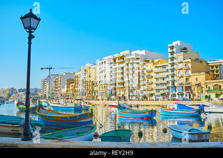 ST Julians, Malte - 20 juin 2018 : le paysage urbain moderne de Spinola Bay avec de nombreux bateaux de pêche sur l'avant-plan, le 20 juin à St Julians. Banque D'Images
