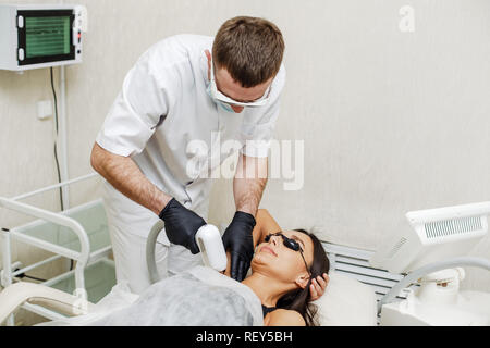 Coiffeur homme l'épilation laser ou l'épilation des aisselles en zone pour femme dans spa salon Banque D'Images