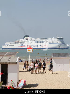 Ferry Calais, France Outward Bound, au port de Douvres, Angleterre, Royaume-Uni [ uk ]. Mon Ferry Ferry vue d'une plage à proximité du port de Calais, France. L'été. Le tourisme. Les touristes sur la plage. Les jeunes s'amuser sur l'appartement de vacances. Cabines de plage . Manche. Sable blanc. Destinations vacances. Banque D'Images