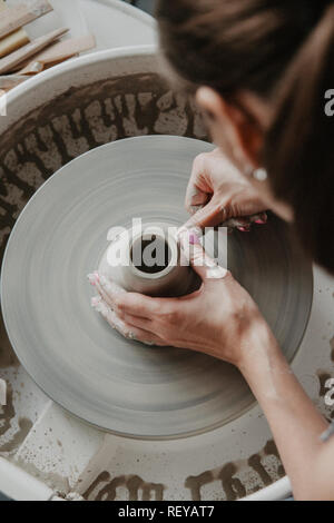 La création d'un pot ou un vase d'argile blanc close-up. Des mains femme cruche d'argile. Banque D'Images