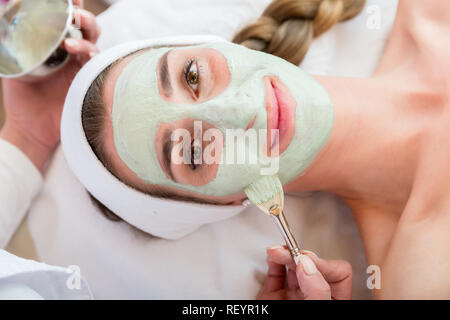 Smiling woman getting facial treatment Banque D'Images