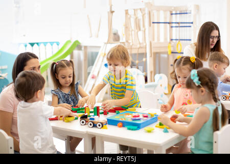 Jardin d'enfants jouant avec des jouets en enseignant à l'âge préscolaire jeux. Concept de l'éducation. Banque D'Images