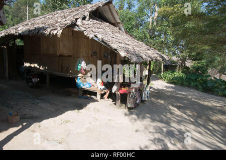 Personne à une cabane dans le village de Hmong Thaïlande villageois assis assis assis assis assis à l'ombre de bois roseaux en bois toit bois bambou arbres indigènes peuple local Banque D'Images