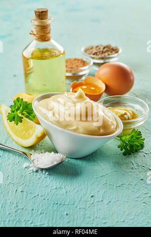 Ingrédients pour faire des mayonnaises gastronomique avec les oeufs, le citron, l'huile et des épices sur le bois vert texturé avec copie espace d'avant-plan Banque D'Images