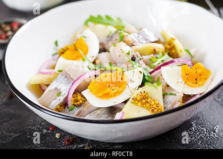 Salade traditionnelle de hareng salé, filet mignon, pommes fraîches, oignon rouge et d'œufs. Ces aliments. La cuisine scandinave. Banque D'Images