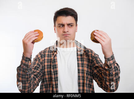 L'homme détient des hamburgers dans ses mains et rend la décision Banque D'Images