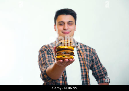 Homme heureux détient deux burger dans la main sur fond blanc Banque D'Images