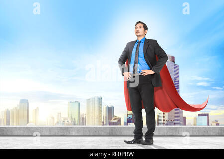 Homme d'attrayants avec cape de super-héros sur le toit du bâtiment de la ville Banque D'Images