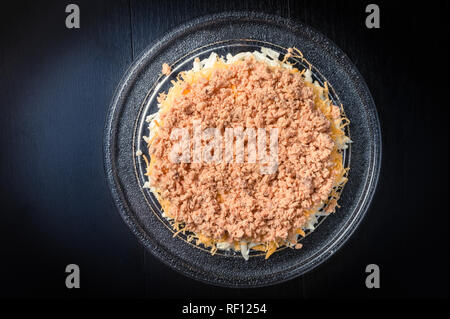 Salade de poisson arrosé de poisson râpé sur dark Banque D'Images