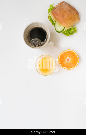 Vue de dessus le petit-déjeuner avec café, jus d'orange, au fromage et une demi-orange sur fond blanc. Banque D'Images