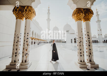 Habillé traditionnellement arabe femme portant burqa noire wisiting la Grande Mosquée Sheikh Zayed à Abu Dhabi, Emirats Arabes Unis. Banque D'Images