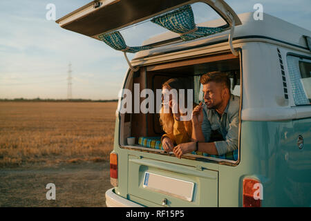 Couple se brosser les dents en camping-van in rural landscape Banque D'Images