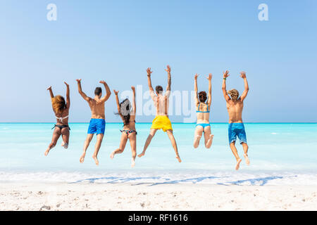 Groupe d'amis à la plage, sautant de joie Banque D'Images