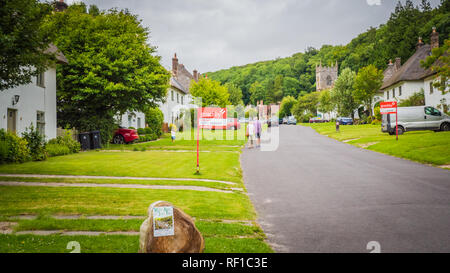 Milton Abbas, Dorset / UK - 0711 2017 : Ancien village médiéval français dans le sud-ouest du Royaume-Uni. Rue avec maisons ancienne chaumière en Angleterre. Banque D'Images
