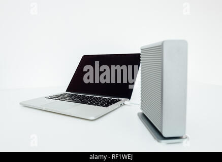 Disque dur Disque dur externe à côté de puissants nouveaux modernes sur ordinateur portable en aluminium tableau blanc - se concentrer sur l'ordinateur Banque D'Images