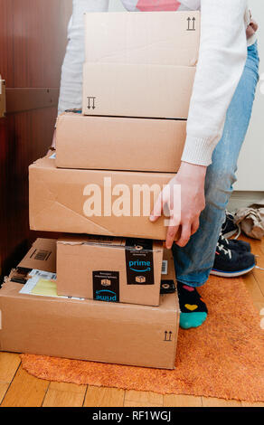 PARIS, FRANCE - 13 jan 2018 : Pile de Amazon premier colis livrés à une porte d'accueil femme préparant pour déballer eux Banque D'Images