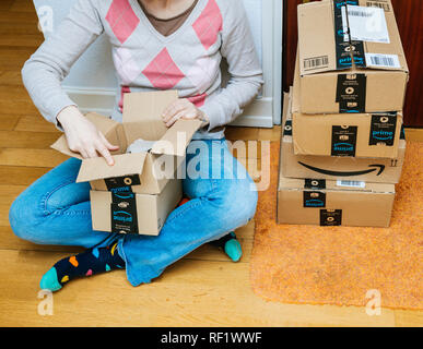 PARIS, FRANCE - 13 jan 2018 : femme unboxing Amazon premier colis livrés à une porte d'accueil pile de boîtes en carton. Banque D'Images