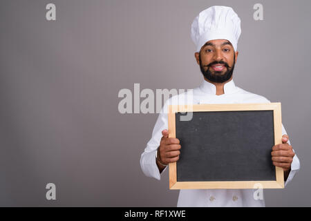 L'homme indien chef holding empty black board with copy space Banque D'Images