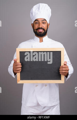 L'homme indien chef holding empty black board with copy space Banque D'Images