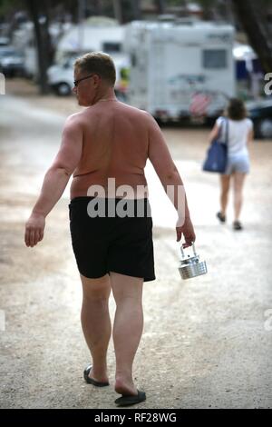 Homme marchant à Poljana Camping pour tentes et véhicules récréatifs, de l'île de Losinj, Croatie, Europe Banque D'Images